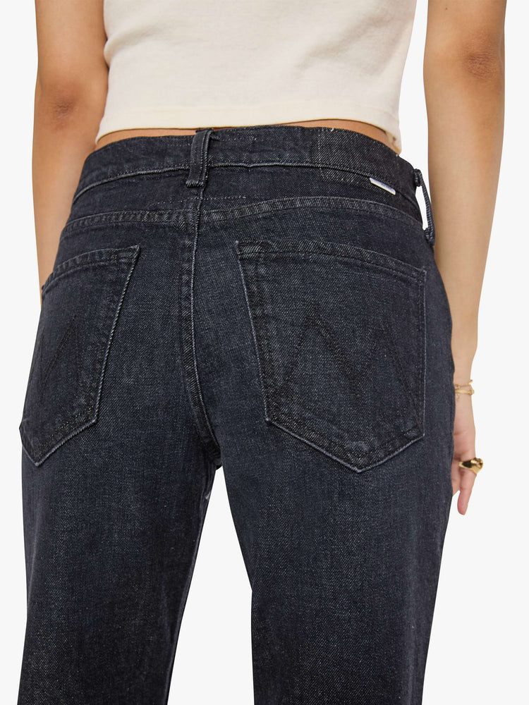 Close up view of a woman in a black straight leg with a bit of a kick, the jean features a mid rise, 30-inch inseam, clean hem and relaxed fit. 