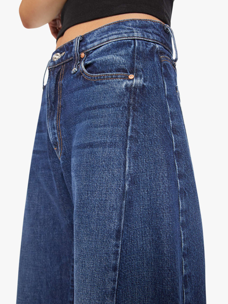 Close up view of a petite woman in a mid-rise jeans designed to sit lower on the hips with a full barrel leg, zip fly, 26.25-inch inseam and a frayed hem.
