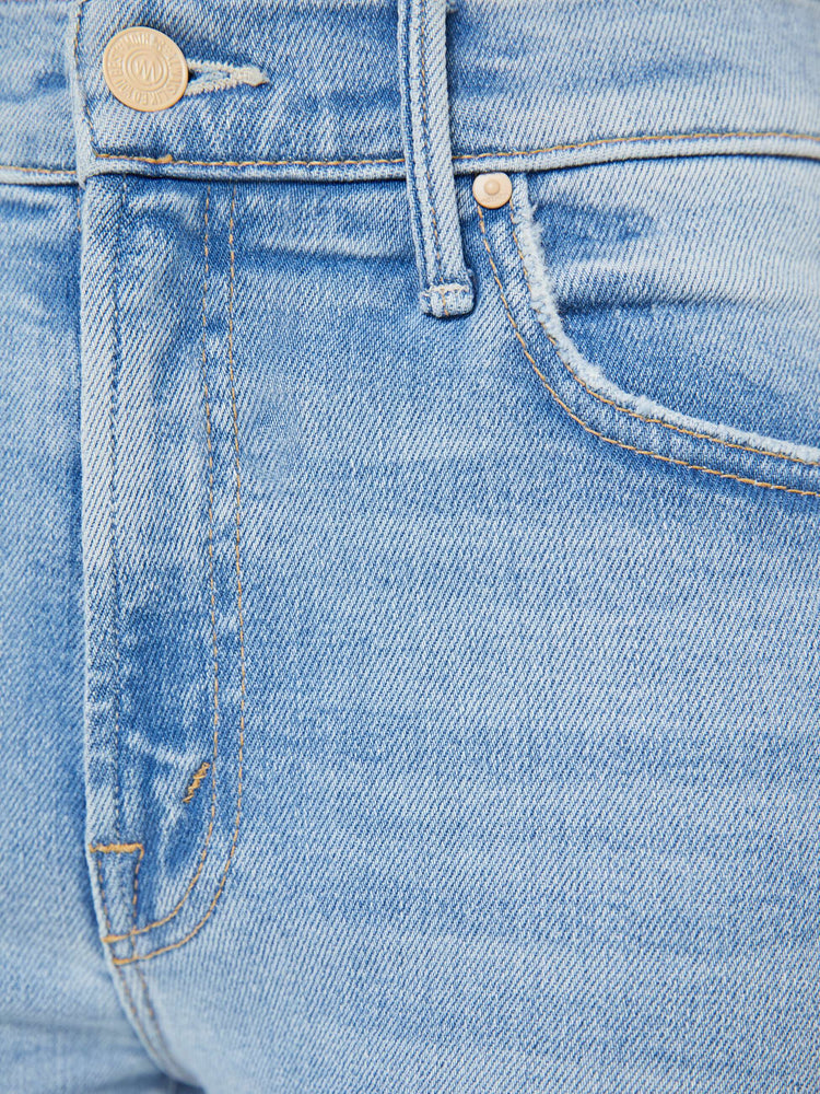 Swatch view of a petite woman light blue high-waisted bootcut hits at the ankle with a frayed step-hem.