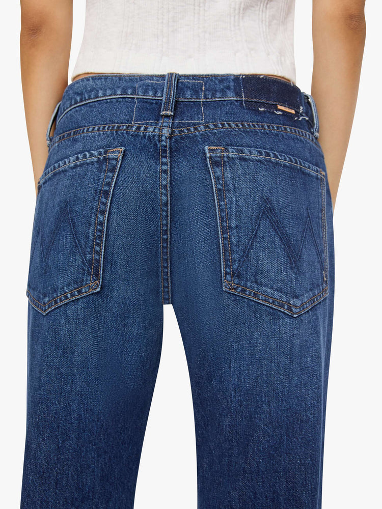 Close up view of a petite woman in a mid-rise bootcut with a zip fly, looser leg, twisted outer seam and a long 32-inch inseam with a clean hem.