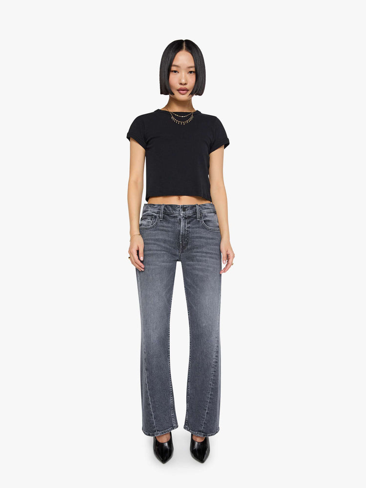 Front view of a woman in a washed grey mid-rise bootcut with a zip fly, looser leg, twisted outer seam and a long 29-inch inseam with a clean hem.