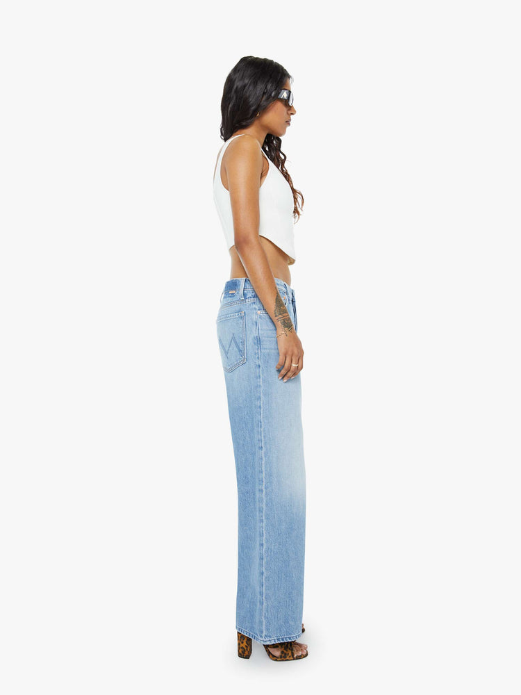 Side view of a petite woman in a high-waisted wide leg jeans with a zip fly, long 29-inch inseam and loose, low-slung fit. 