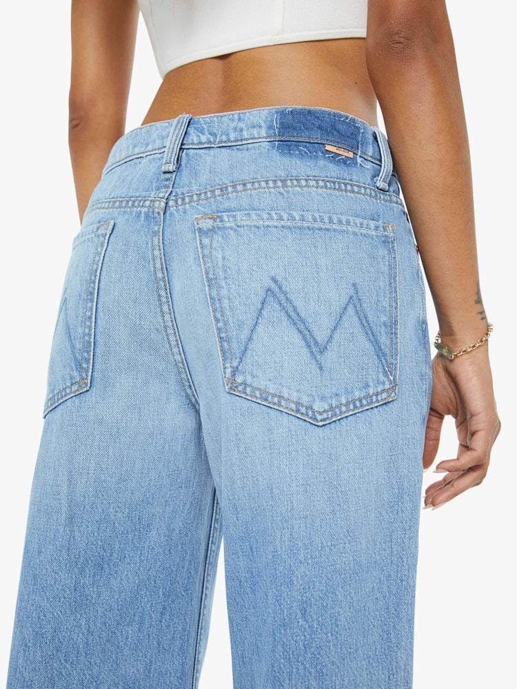 Close up view of a petite woman in a high-waisted wide leg jeans with a zip fly, long 29-inch inseam and loose, low-slung fit. 