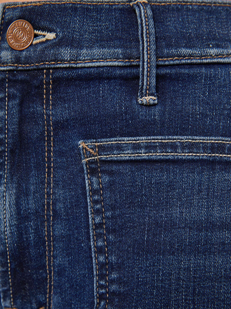 Swatch view of a woman in a dark blue mid-rise jeans with a loose fit, wide leg, patch pockets, zip fly and 29-inch inseam with a clean hem.
