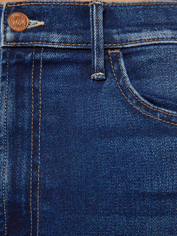 Swatch view of a petite woman in a dark blue  high-rise flare has an ankle-length inseam and a clean hem. 