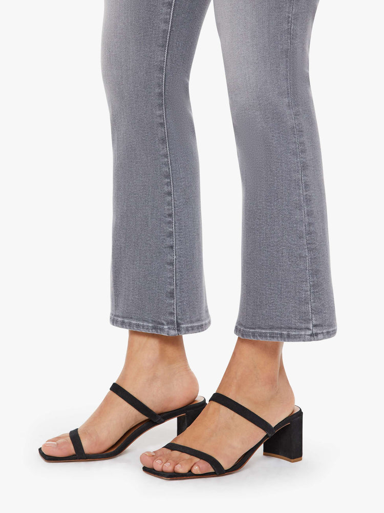 Hem view of a petite woman in a grey high-rise flare has a zip fly, ankle-length inseam and a clean hem.