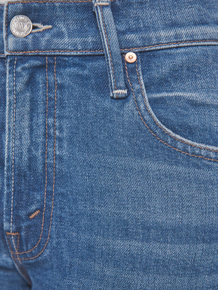Swatch view of woman in a mid-blue jean with a high-rise bootcut has an ankle-length inseam, zip fly and a clean hem.