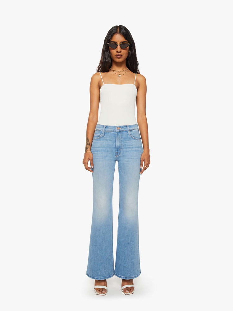 Front view of a woman in a light blue  high-rise flare with a zip fly, long 30-inch inseam and a clean hem. 
