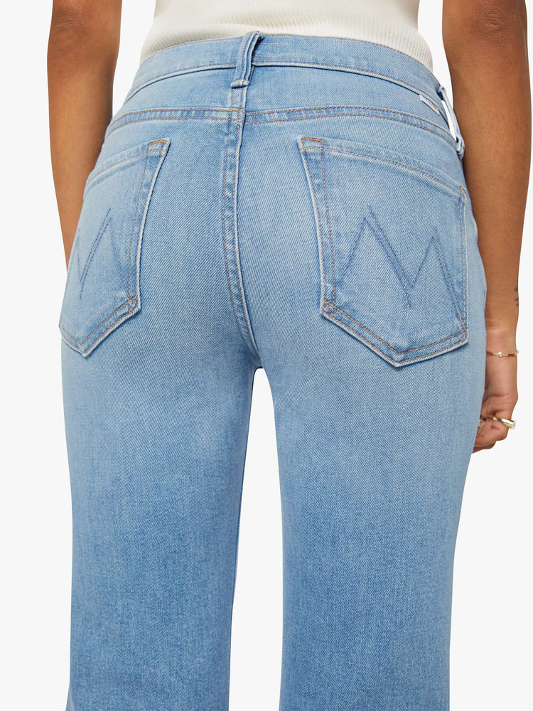 Close up view of a woman in a light blue  high-rise flare with a zip fly, long 30-inch inseam and a clean hem. 