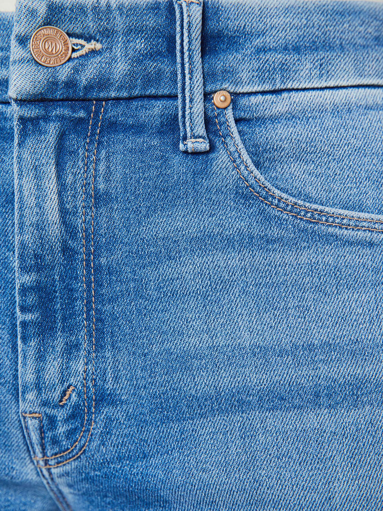 Swatch  view of a woman in a mid blue high waisted wide leg jean with a 29-inch inseam and a frayed hem.