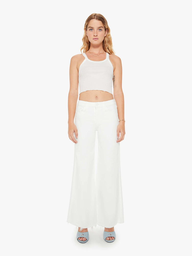 Front view of a woman petite white denim high-waisted wide leg has a full-length inseam and a frayed hem.