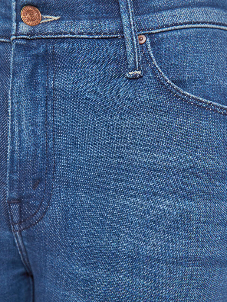 Swatch view of a petite woman in a med blue flare jean has a mid rise, zip fly, sneaker-length inseam and a clean hem.