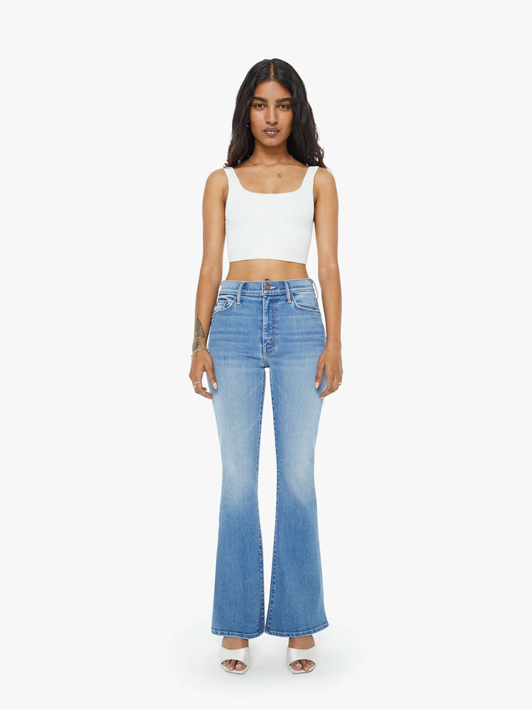 Front view of a petite woman flare jean has a mid rise with a sneaker-length inseam and a clean hem in mid-blue wash.
