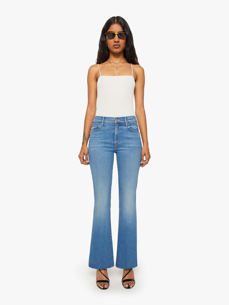 Front view of a petite woman in a mid blue mid rise with a 28-inch inseam and a clean hem.