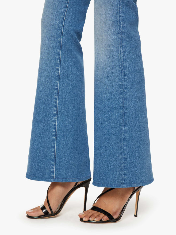 Close up view of a petite woman in a mid blue mid rise with a 28-inch inseam and a clean hem.
