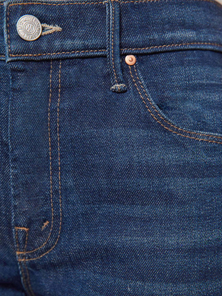 Swatch view of a woman in a dark blue flare jean has a mid rise with a 28-inch inseam and a clean hem.