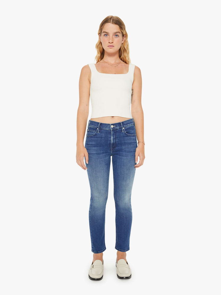 Front view of a petite woman mid-rise straight leg jean its at the ankle with a clean hem in a mid blue wash.