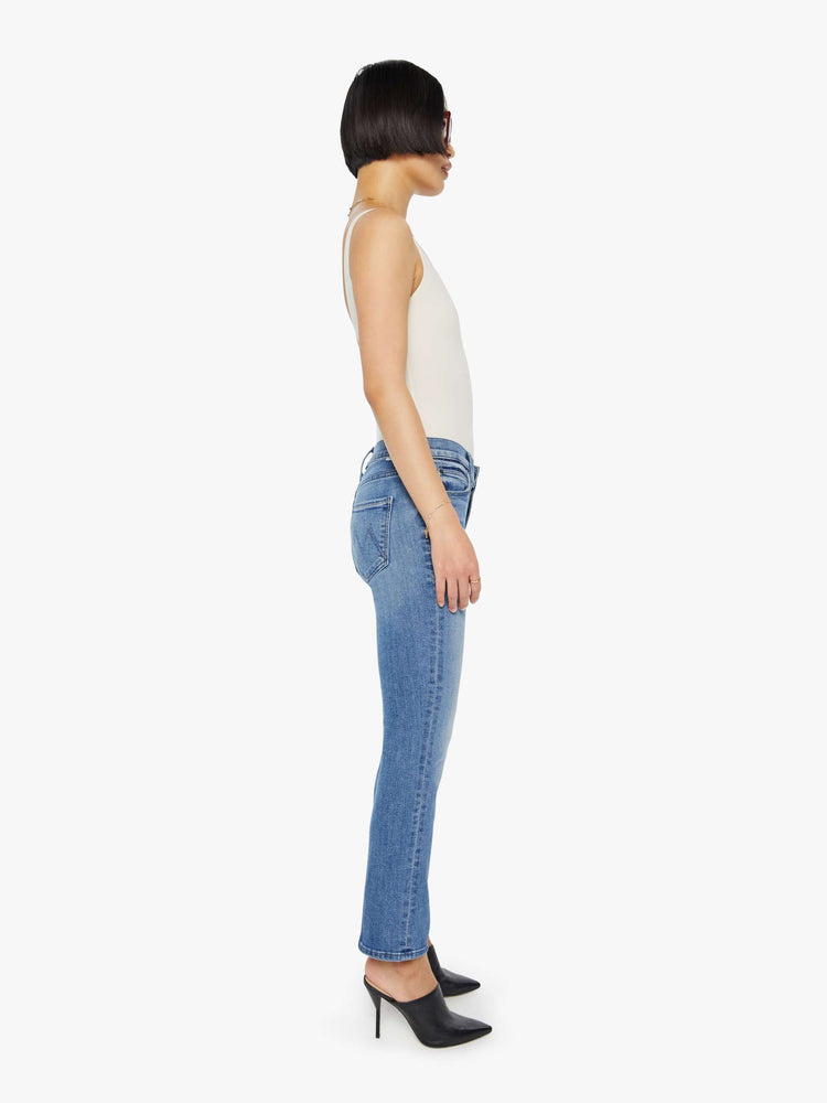 Side view of a womens medium blue wash jean featuring a mid rise and straight leg with an ankle length clean hem.