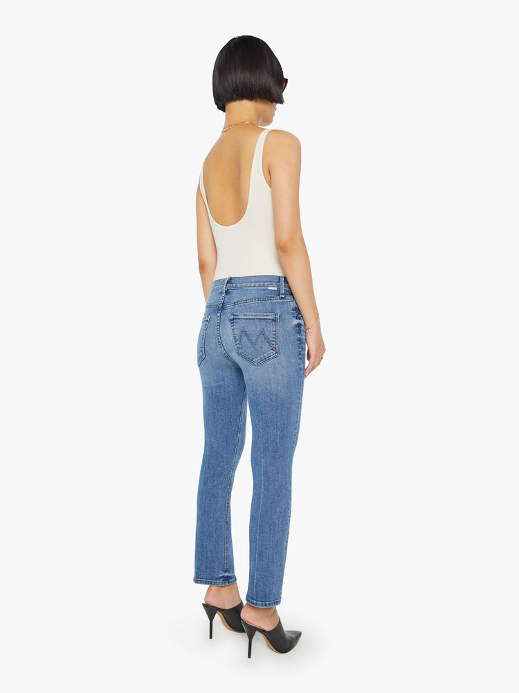 Back view of a womens medium blue wash jean featuring a mid rise and straight leg with an ankle length clean hem.