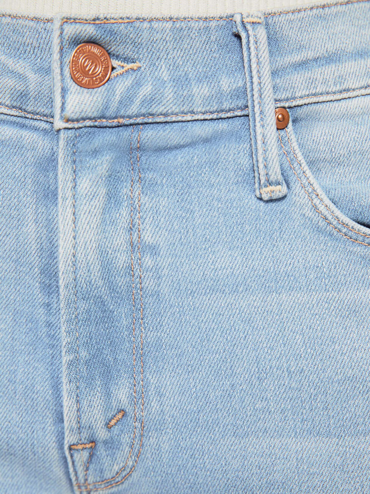 Back close up view of a petites woman in a mid-rise straight leg hits at the ankle with a frayed hem in a medium blue wash.