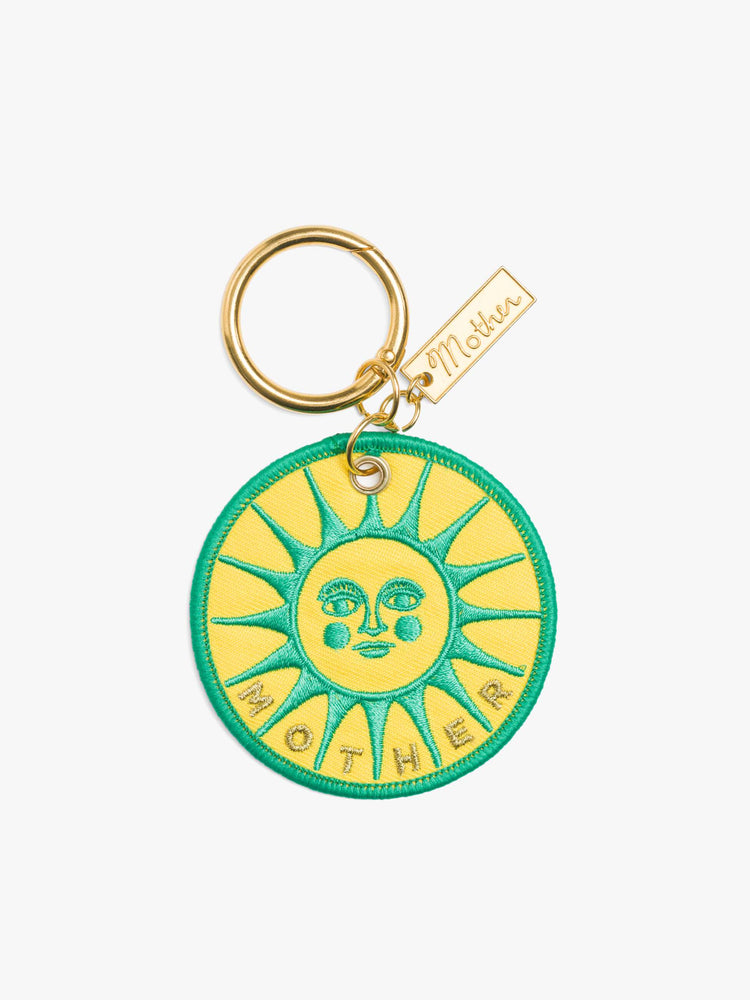 Back view of a vintage-inspired keychain with a 2.5-inch patch and 1.25-inch ring in pink and green on one side and a sun graphic and MOTHER's name in yellow, green and gold on the other.