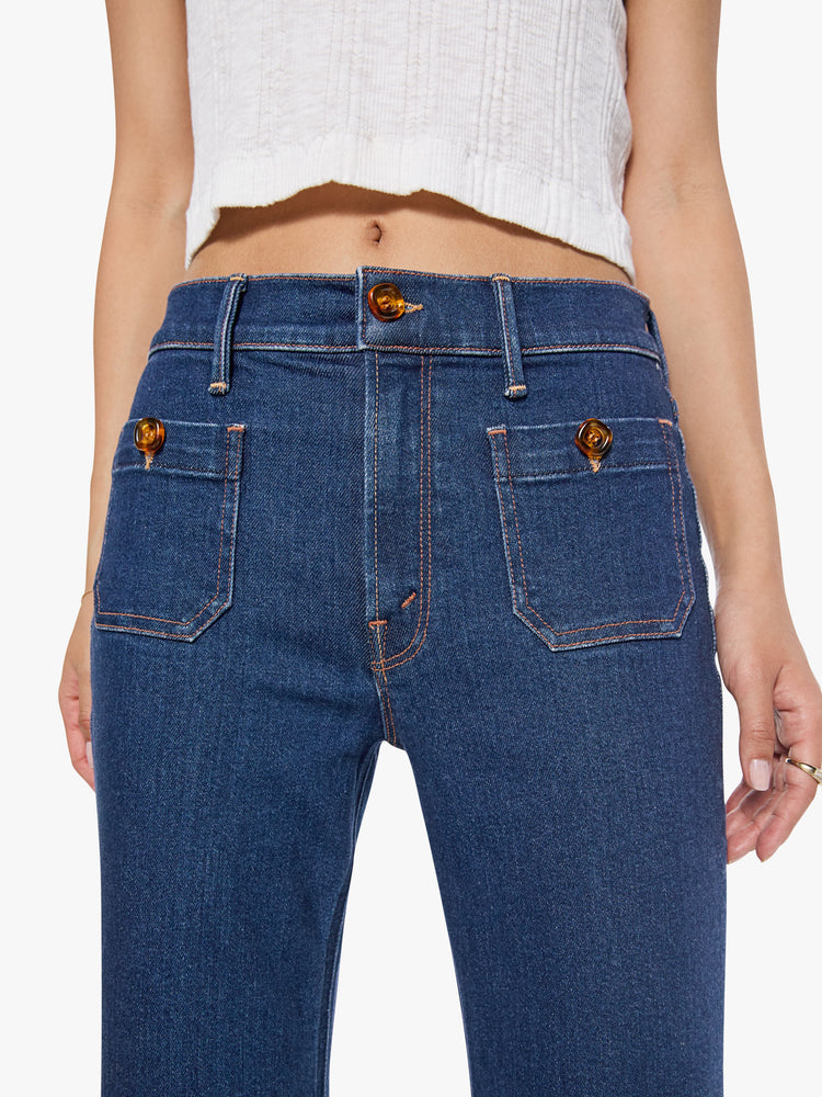 Front close up view of a high rise dark blue denim flare jeans with front patch pockets.