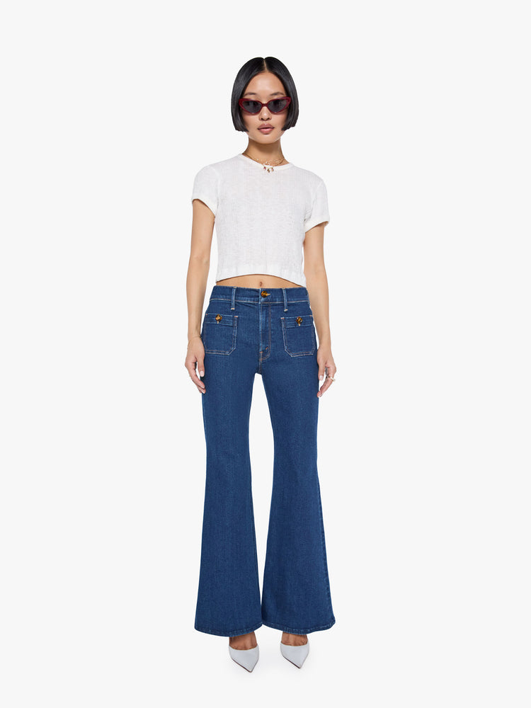 Front view of a high rise dark blue denim flare jeans with front patch pockets.