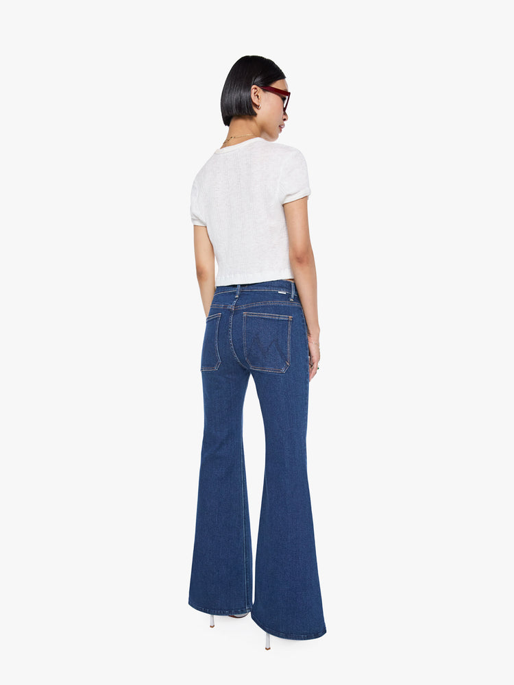 Back view of a high rise dark blue denim flare jeans with back square pockets.