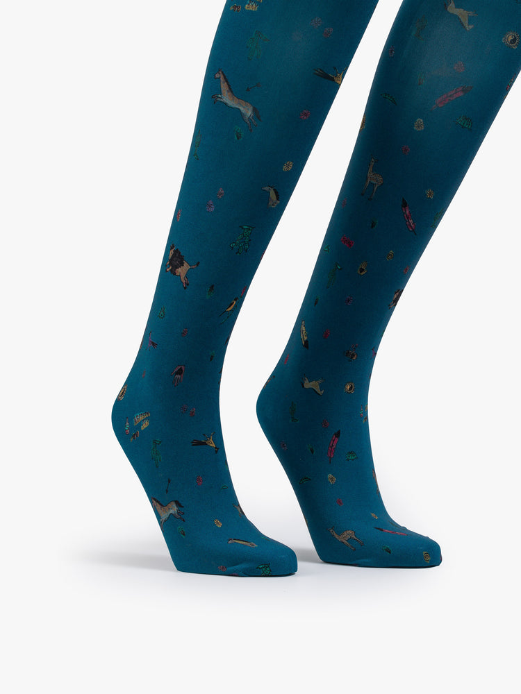 Feet view of a woman high-waisted tights are designed in blue with Western-inspired motifs,small horses, cacti, flowers and more in blue.