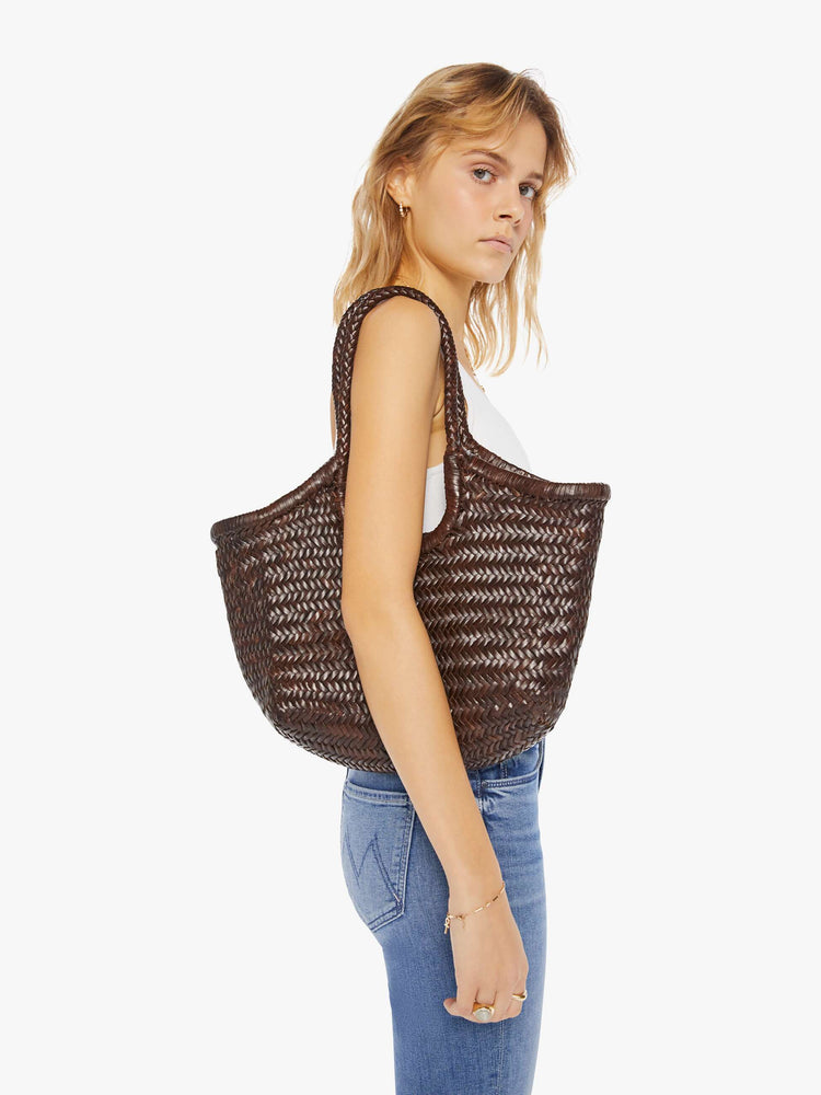 Side view of a woman with a large brown women bag.