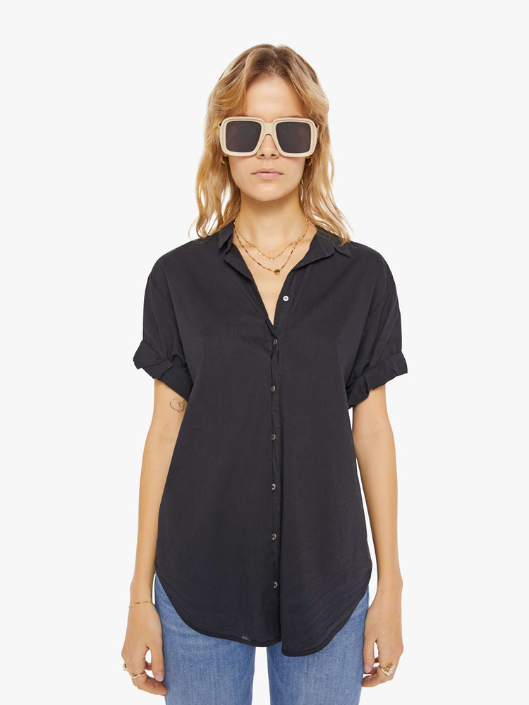 Front view of a woman wearing a black short sleeve button up shirt