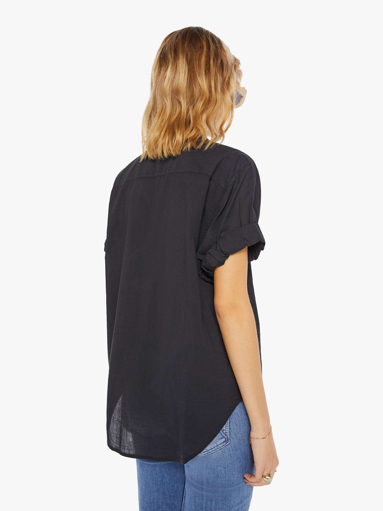 Back view of a woman wearing a black short sleeve button up shirt