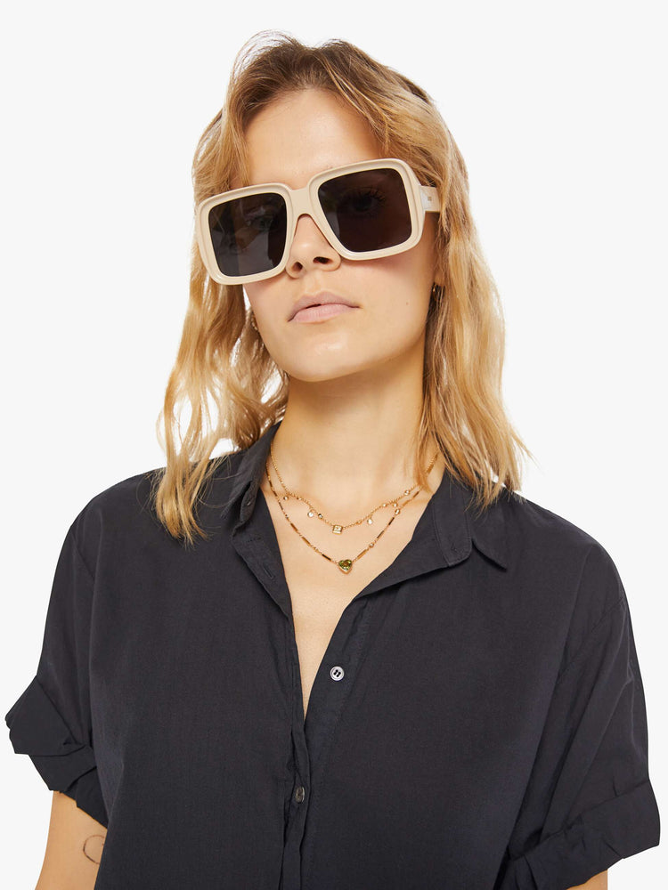 Detail view of a woman wearing a black short sleeve button up shirt