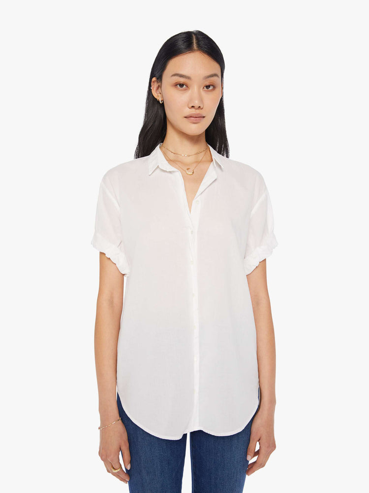 Front view of a woman wearing a white short sleeve button up shirt