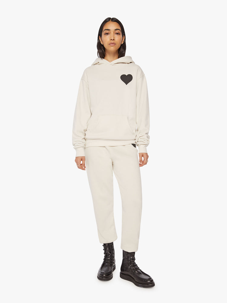 Front full body view of a Womens white hoodie pullover with a front kangaroo pocket and a black heart graphic printed on the chest.