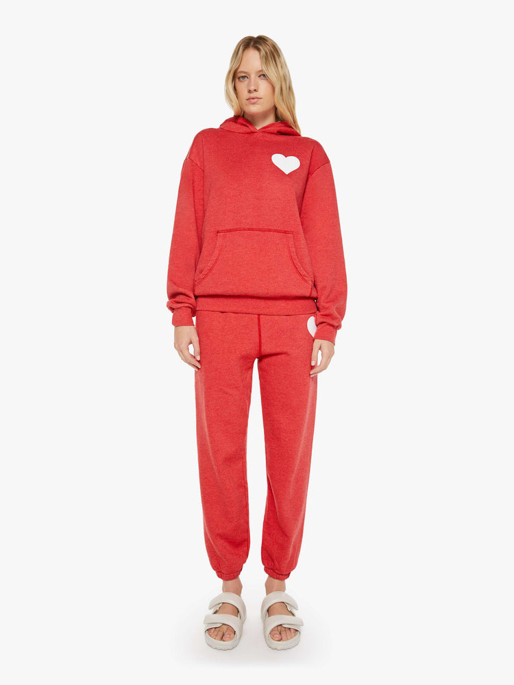 Full body view of a woman in red sweatshirt has a front patch pocket and a loose, comfortable fit.