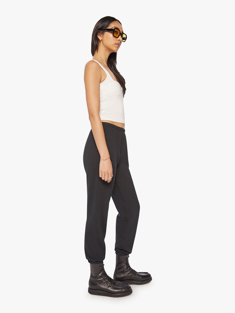 Full body side profile view of a Womens black sweatpant with a white heart graphic printed on the left side hip.