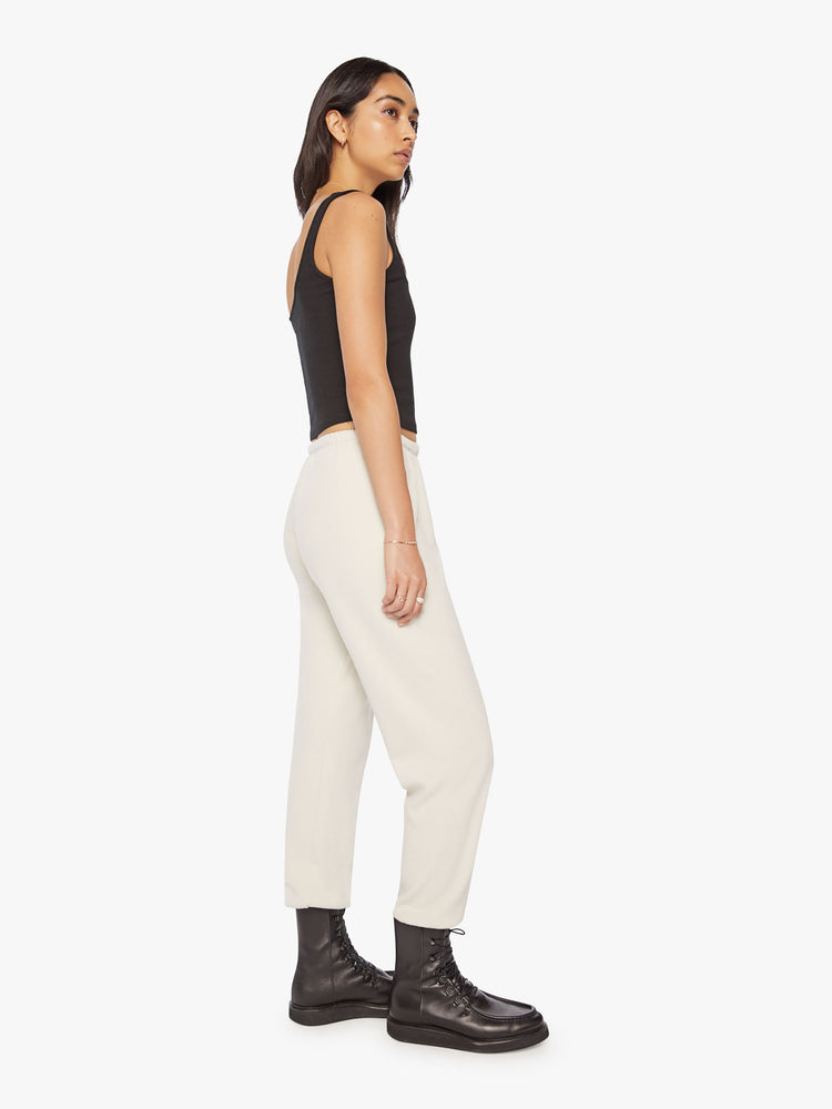 Full body side profile view of a Womens white sweatpant with a black heart graphic printed on the left side hip.