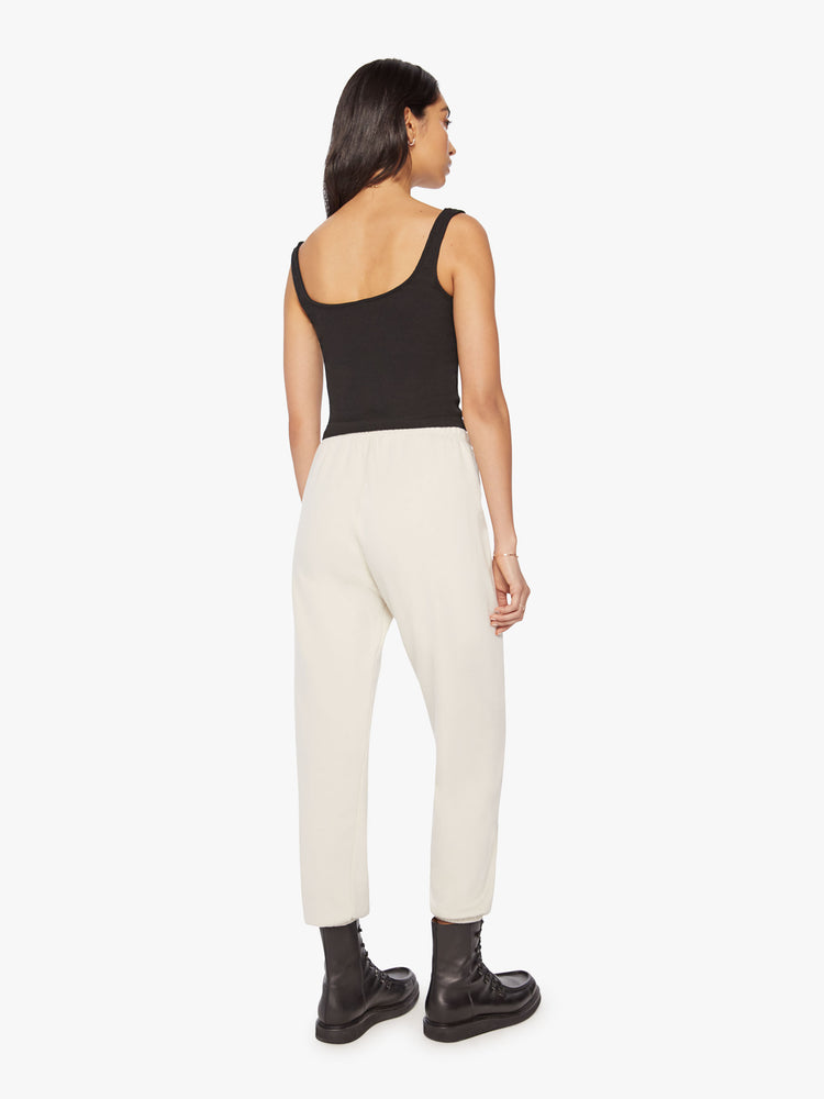 Full body back view of a Womens white sweatpant with a black heart graphic printed on the left side hip.