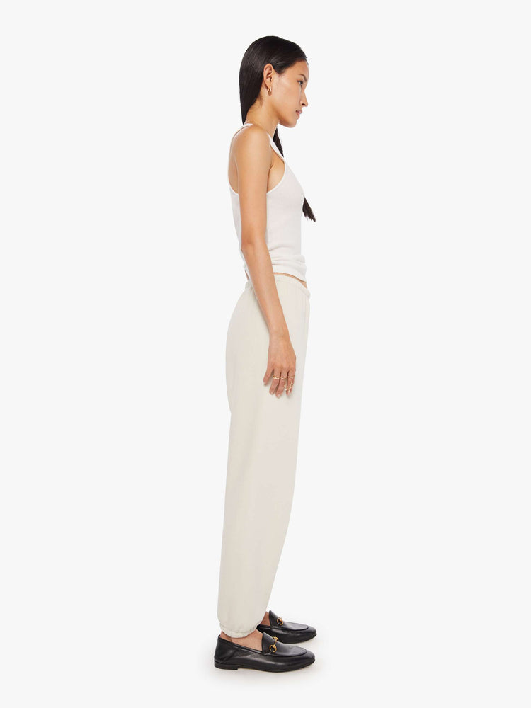 Full body side profile view of a Womens white sweatpant with a black heart graphic printed on the left side hip.