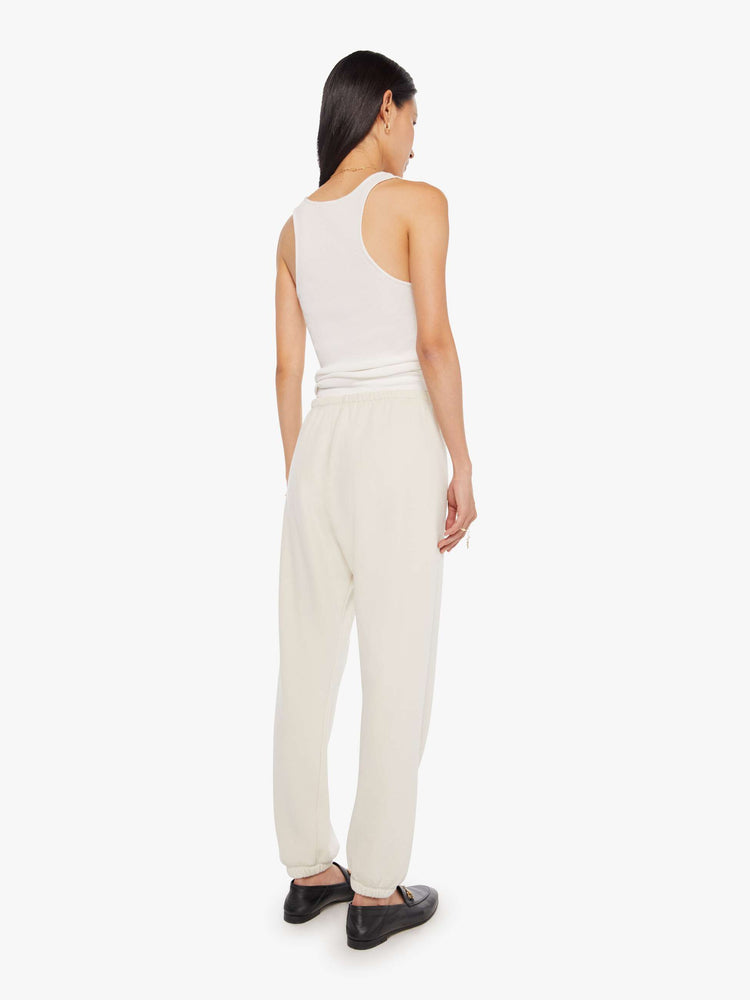 Full body back view of a Womens white sweatpant with a black heart graphic printed on the left side hip.