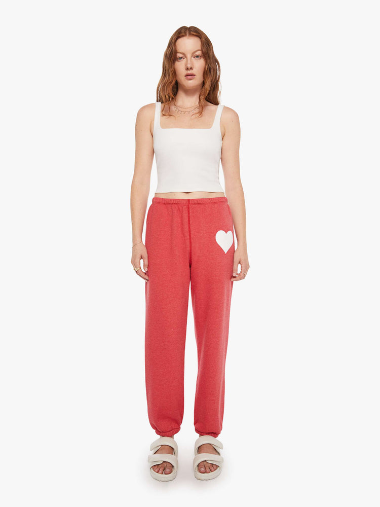 Front view of a woman in red sweatpants have an elastic waist and cuffs for a loose, comfortable fit.