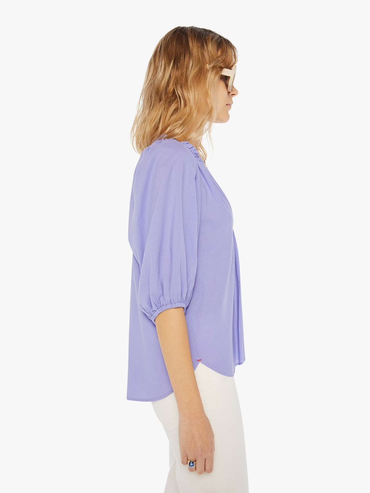 Side view of a womens light purple blouse featuring a v neck, elastic 3/4 length sleeves, and a flowy fit.