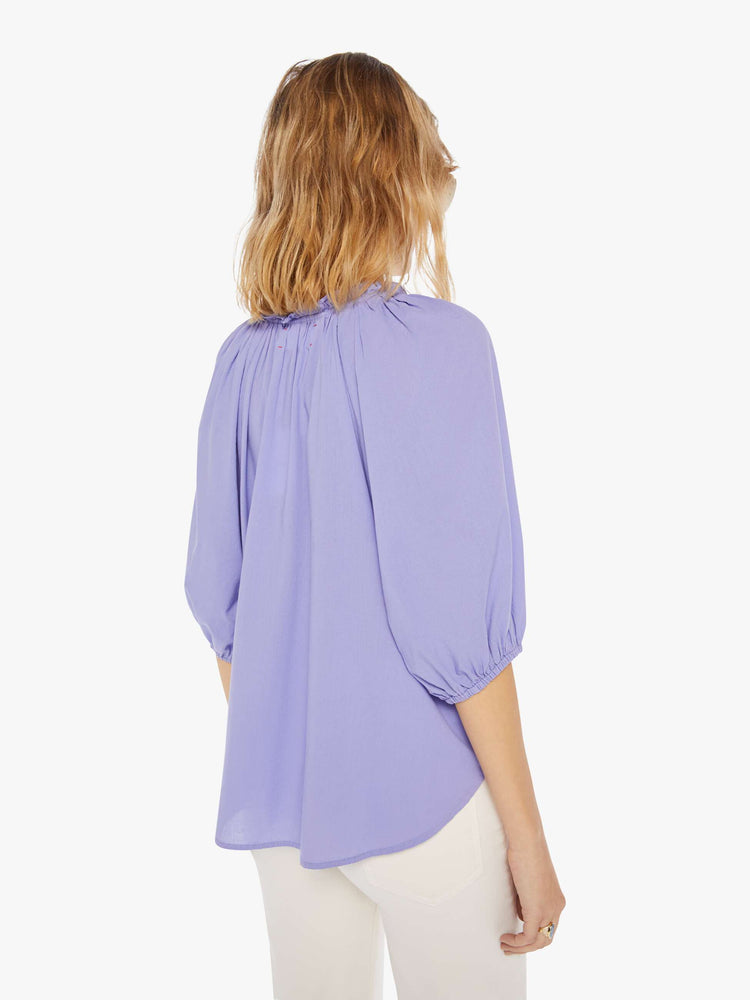 Back view of a womens light purple blouse featuring a v neck, elastic 3/4 length sleeves, and a flowy fit.