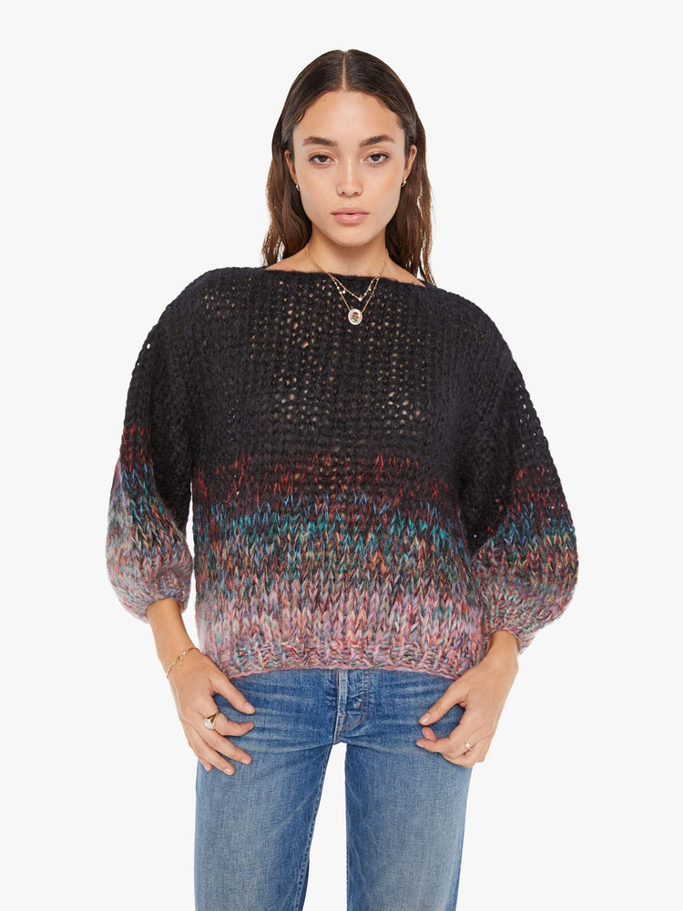 Front view of a womens chunky knit sweater featuring a black to multi color gradient and billow sleeves.