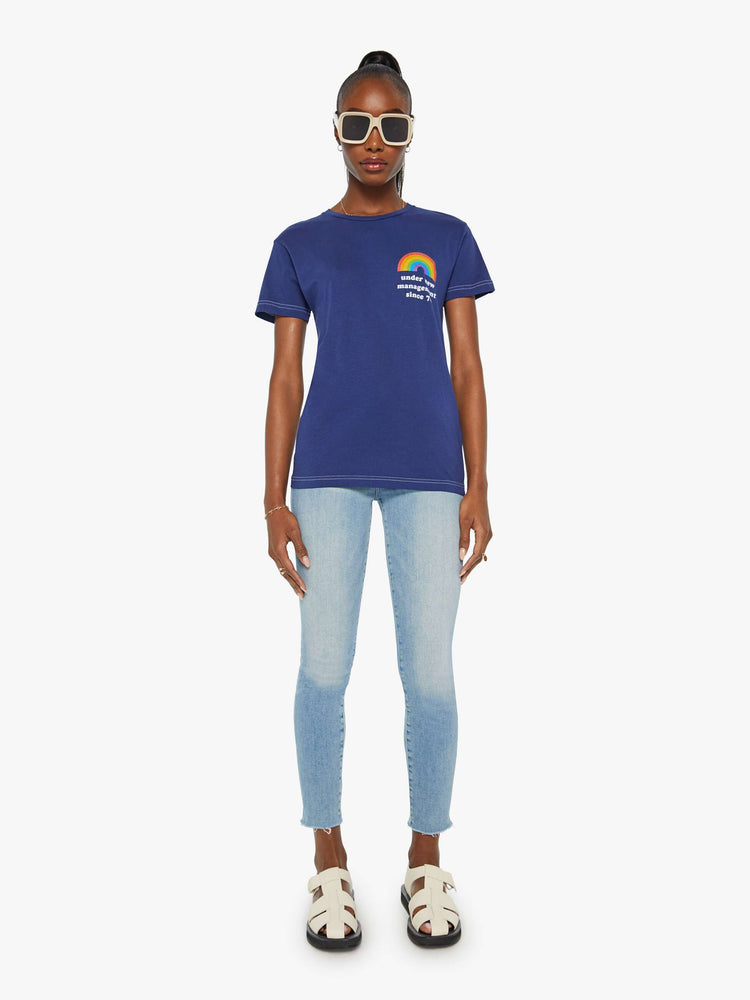 Front full body view of a women's Navy t-shirt with a rainbow and "under new management since '74" graphic.