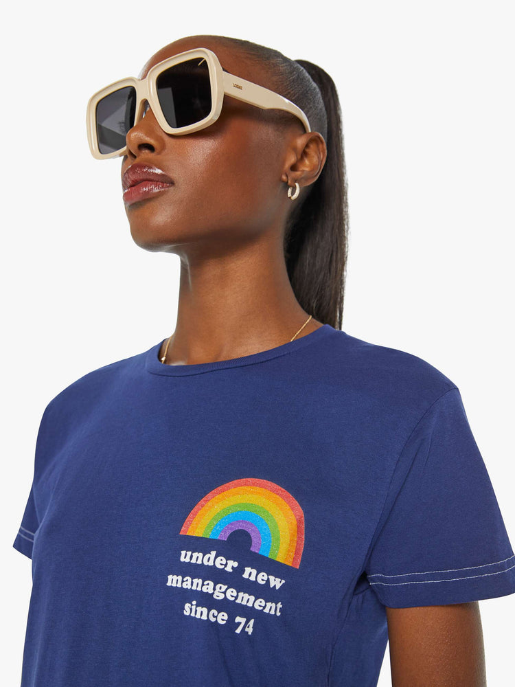 Front close up view of a women's Navy t-shirt with a rainbow and "under new management since '74" graphic.