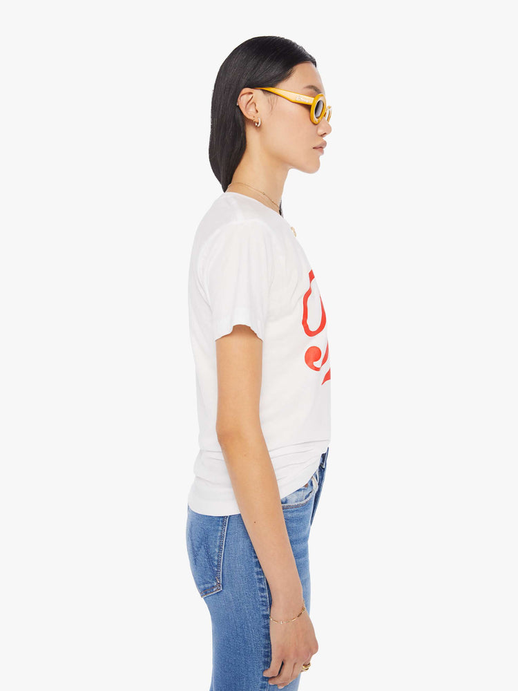 Side view of a women's white t-shirt with red "Fake" graphic