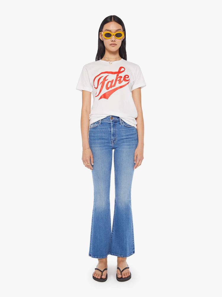 Front full body view of a women's white t-shirt with red "Fake" graphic