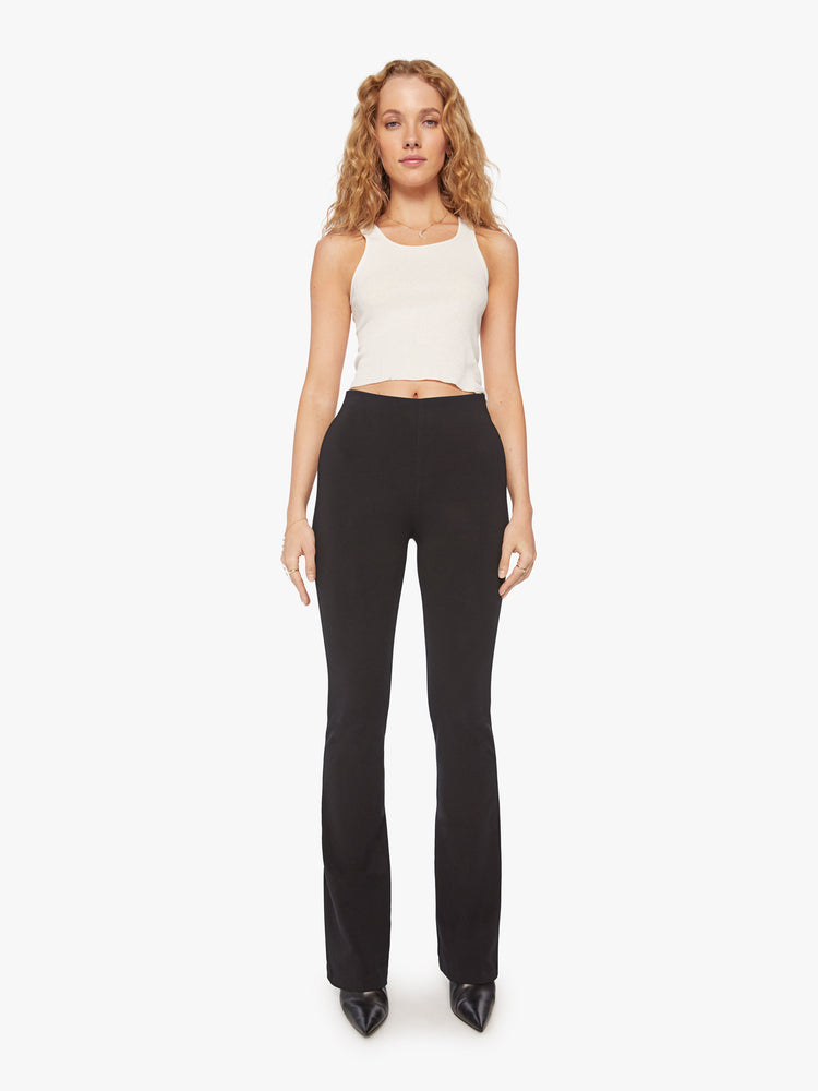 Front full body view of a womens black high rise pant featuring a fitted flare leg